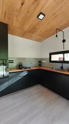 a kitchen with black cabinets and a wooden ceiling at Aire in La Estancia