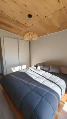 a large blue bed in a bedroom with a wooden ceiling at Aire in La Estancia