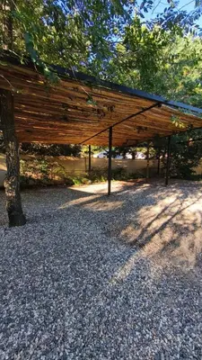 a wooden pavilion sitting under a tree in a park at Aire in La Estancia