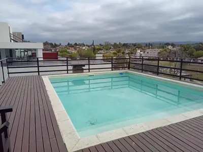 a swimming pool on the roof of a building at Departamento Paseo Quattro in Villa Carlos Paz