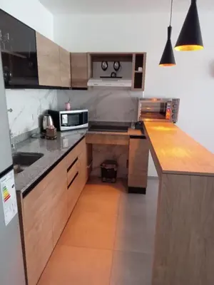 a kitchen with wooden cabinets and a counter top at Departamento Paseo Quattro in Villa Carlos Paz