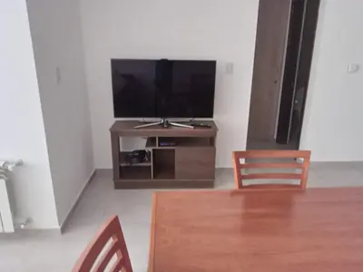 a living room with a flat screen tv on a wooden entertainment center at Departamento Paseo Quattro in Villa Carlos Paz