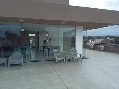 a patio with chairs and tables on a building at Departamento Paseo Quattro in Villa Carlos Paz