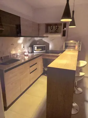 a kitchen with wooden cabinets and a counter top at Departamento Paseo Quattro in Villa Carlos Paz