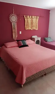 a bedroom with a large bed with a red wall at Casa Nacha in Cuesta Blanca