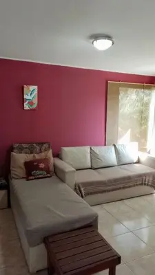 a living room with a couch and a red wall at Casa Nacha in Cuesta Blanca