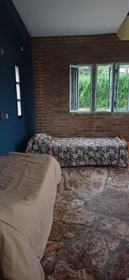 a bedroom with two beds and a brick wall at naulitus in Villa Icho Cruz