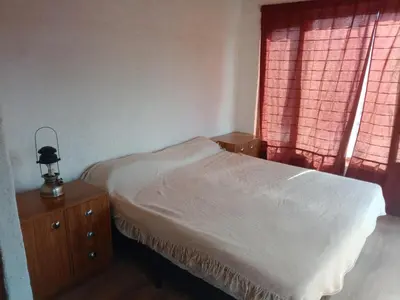 a small bedroom with a bed and a window at Frente al Río Grande in Trapiche