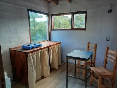 a room with a table and a chair and a window at Frente al Río Grande in Trapiche