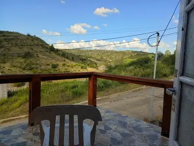 a chair on a porch with a view of a mountain at Frente al Río Grande in Trapiche