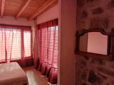 a bedroom with red curtains and a bed and a mirror at Frente al Río Grande in Trapiche