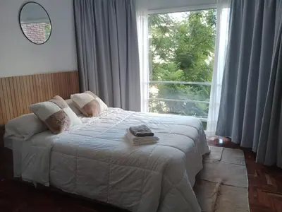 a bedroom with a bed with a large window at Encantador departamento en Nueva Córdoba in La Porteña