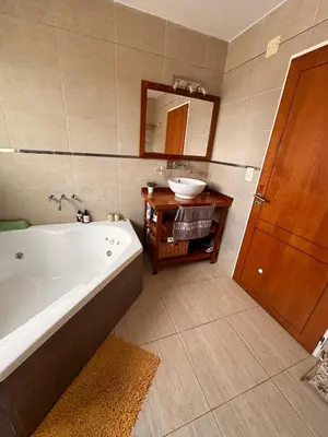 a bathroom with a tub and a sink and a mirror at Casa Valle del Colibrí in Merlo