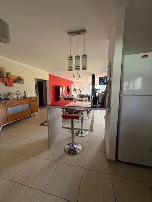 a kitchen with a table and a refrigerator at Casa Valle del Colibrí in Merlo