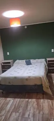 a bedroom with a bed with a green wall at Buena tierra in Arroyo de Los Patos