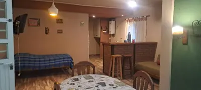 a living room with a table and a kitchen at Buena tierra in Arroyo de Los Patos