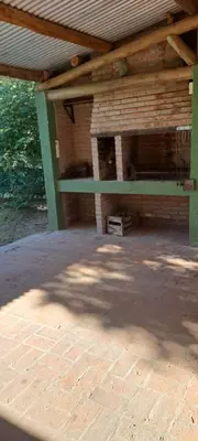 an outdoor patio with a brick fireplace and a wooden roof at Buena tierra in Arroyo de Los Patos
