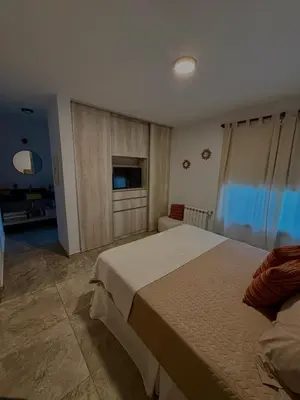 a bedroom with a large bed and a television at Estilo y Relax en Manantiales ll in Cordoba