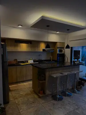 a kitchen with wooden cabinets and a island with bar stools at Estilo y Relax en Manantiales ll in Cordoba