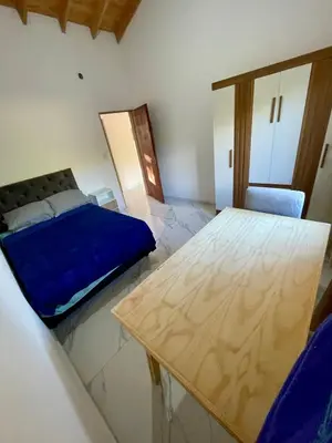 a bedroom with a bed and a wooden table at Las Mariposas in Merlo