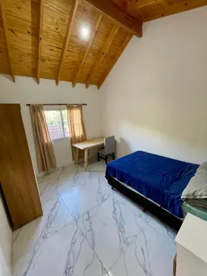 a bedroom with a bed and a desk in it at Las Mariposas in Merlo