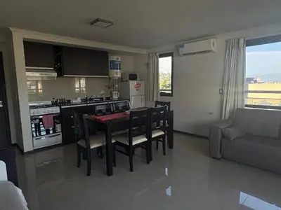 a kitchen and living room with a table and chairs at Hermoso departamento en el Centro de Carlos Paz in Villa Carlos Paz