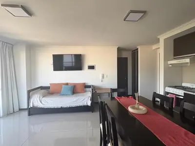 a bedroom with a bed and a dining room with a table at Hermoso departamento en el Centro de Carlos Paz in Villa Carlos Paz