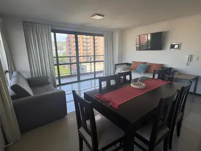 a living room with a dining room table and a couch at Hermoso departamento en el Centro de Carlos Paz in Villa Carlos Paz