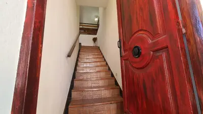 a red door leading to a staircase with a red stair case at El Tesoro Cordobés in Cordoba