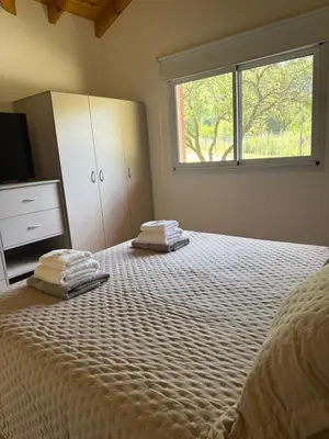 a bedroom with a bed with two towels on it at Treffen Cabañas in Villa General Belgrano