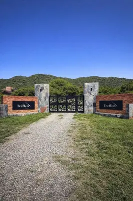 a gate at the end of a dirt road at Treffen Cabañas in Villa General Belgrano