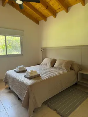 a bedroom with a bed with two towels on it at Treffen Cabañas in Villa General Belgrano