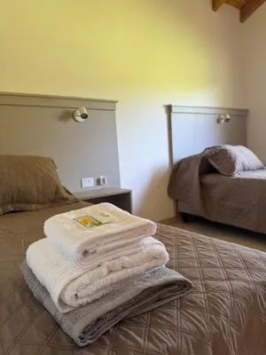 a pile of towels sitting on top of a bed at Treffen Cabañas in Villa General Belgrano
