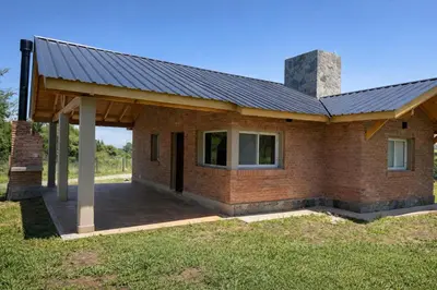 a house with a metal roof and a patio at Treffen Cabañas in Villa General Belgrano