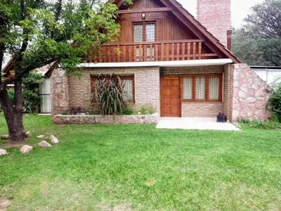 a house with a grass yard in front of it at Cabaña Dario in Villa Independencia