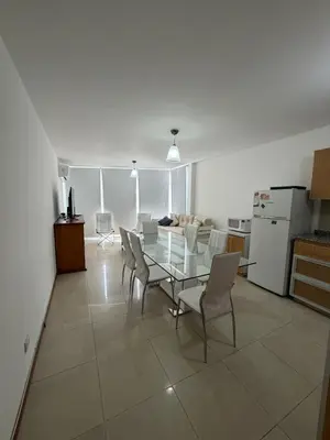 a living room with a glass table and chairs at Departamento Carilo in Villa Carlos Paz