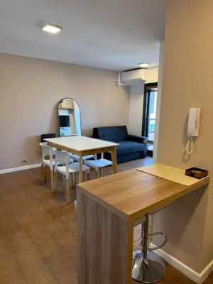 a living room with a table and a blue couch at Departamento Nueva Córdoba in Cordoba