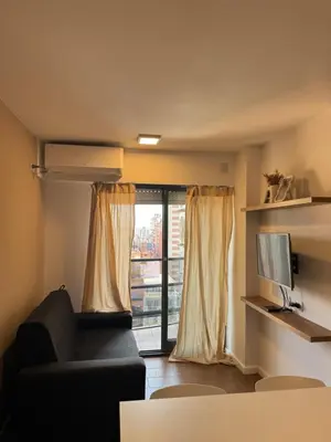 a living room with a couch and a window at Departamento Nueva Córdoba in Cordoba
