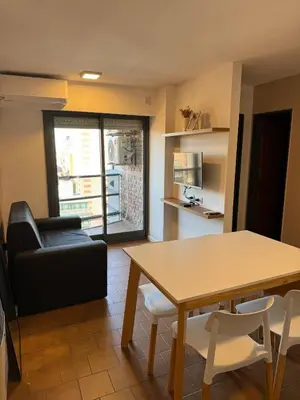 a living room with a table and a couch at Departamento Nueva Córdoba in Cordoba