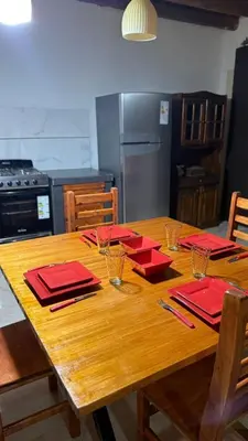 a wooden table with red napkins on it in a kitchen at Refugio del Alma in Villa Anizacate