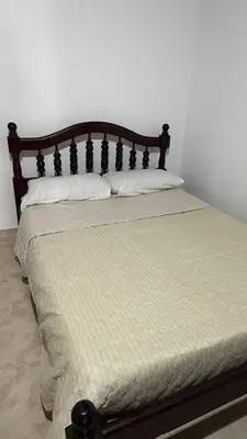 a bed with a wooden headboard in a bedroom at Refugio del Alma in Villa Anizacate