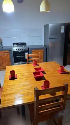 a wooden table in a kitchen with red dishes on it at Refugio del Alma in Villa Anizacate