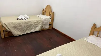 two twin beds in a room with wooden floors at Refugio del Alma in Villa Anizacate