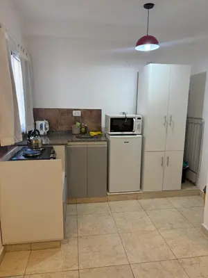 a kitchen with white cabinets and a white refrigerator at Amelia 2-4 in Villa Carlos Paz