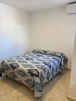 a bed in a room with a blanket on it at Amelia 2-4 in Villa Carlos Paz