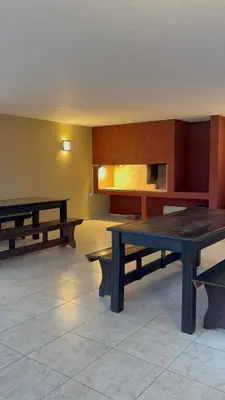 a room with two tables and benches in it at Amelia 2-4 in Villa Carlos Paz