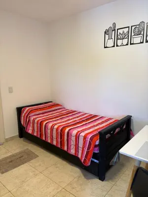 a bed in a room with a striped blanket on it at Amelia 2-4 in Villa Carlos Paz