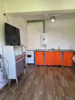 a room with a kitchen with a tv and a counter at Short-Term Rental in Bialet Massé