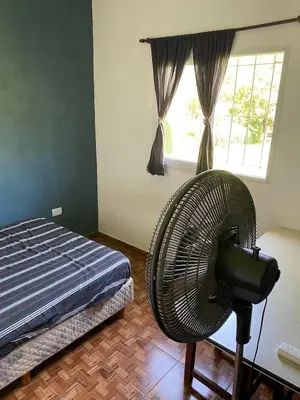 a bedroom with a fan in front of a bed at Short-Term Rental in Bialet Massé