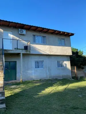 a building with a green door and windows at Short-Term Rental in Bialet Massé